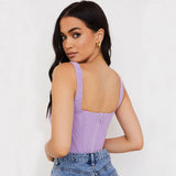 woman wearing a purple corset top and blue jeans, back view