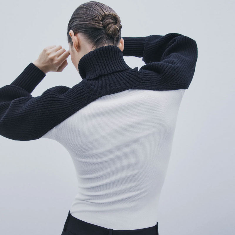 woman wearing a black and white ribbed turtleneck sweater