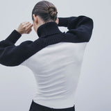 woman wearing a black and white ribbed turtleneck sweater