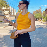 woman wearing a yellow striped crop top and black pants