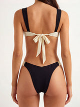 back view of a woman wearing a black and beige bikini