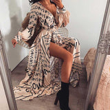 woman wearing a beige maxi dress with a black letter print, sitting in a chair, with a mirror reflection