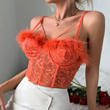 Woman wearing an orange lace corset top with feather trim and a white skirt.