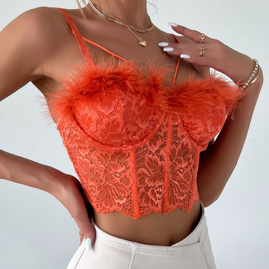 Woman showing off jewelry while wearing an orange lace corset top.